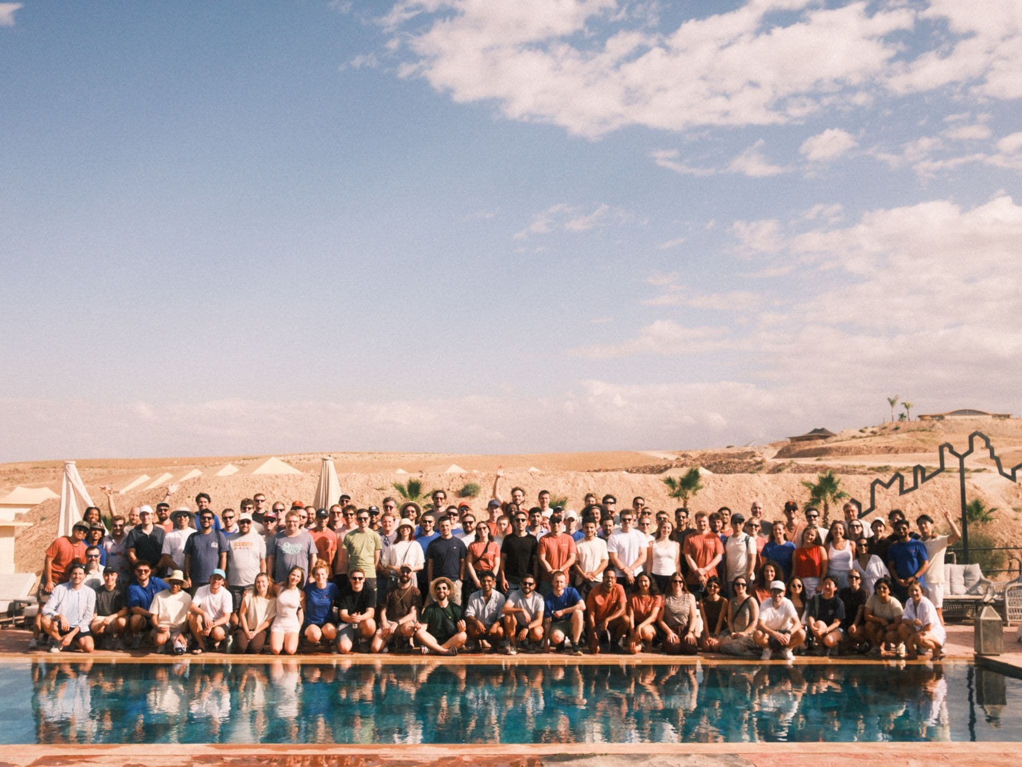 The Granola team gathered beside a pool at a company offsite